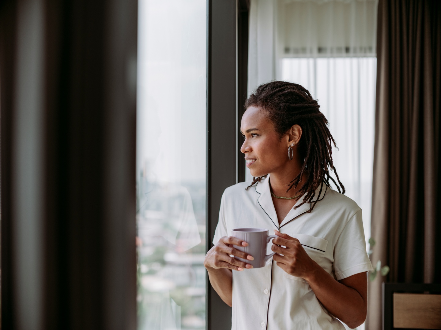 Resident enjoying skyline view & coffee by the window